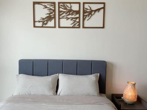 een bed met vier foto's op de muur erboven bij Green Haven 1 Bedroom in Masai