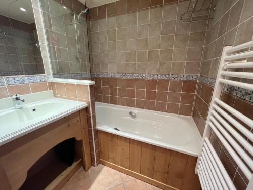 a bathroom with a tub and a sink and a bath tub at Appartement Lanslebourg-Mont-Cenis, 2 pièces, 4 personnes - FR-1-508-286 in Lanslebourg-Mont-Cenis
