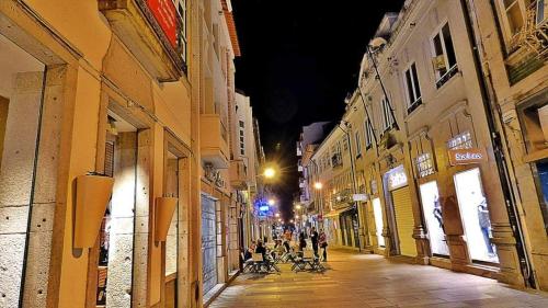 a group of people walking down a street at night at Casa da fonte de baixo in Barcelos