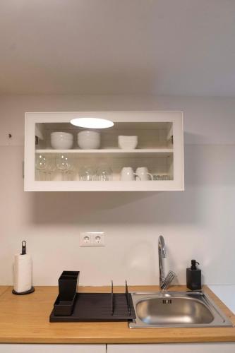 a kitchen with a sink and a shelf with dishes at Casa da fonte de baixo in Barcelos