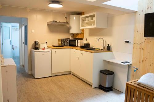 a small kitchen with white cabinets and appliances at Casa da fonte de baixo in Barcelos