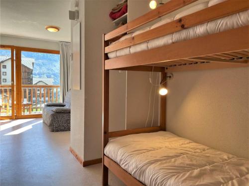 - une chambre avec 2 lits superposés et un balcon dans l'établissement Appartement 2 pièces, 6 pers, animaux admis, parking, près des pistes - FR-1-525-281, à Saint-Étienne-en-Dévoluy