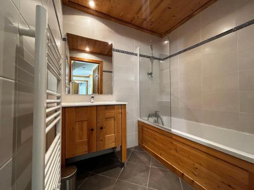 une salle de bain avec une baignoire et un lavabo et une baignoire dans l'établissement Appart spacieux 8 pers, ski aux pieds, parking, wifi inclus - FR-1-508-294, à Lanslebourg-Mont-Cenis