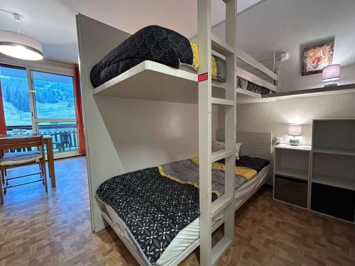 a bunk bed in a room with a desk and a bed at Appartement Le Dévoluy, 1 pièce, 4 personnes - FR-1-525-273 in Le Dévoluy