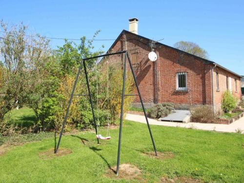 a swing set in the grass in front of a building at Maison de plain-pied avec jardin clos, proche Haras du Pin et Mémorial de Montormel, animaux acceptés - FR-1-497-191 in Saint-Pierre-la-Rivière