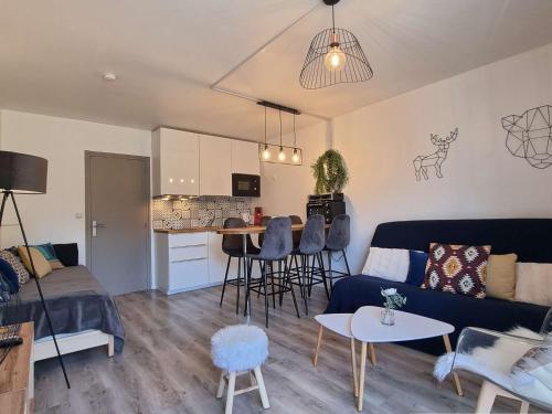 un salon avec un canapé bleu et une cuisine dans l'établissement Studio rénové 4 pers. avec WiFi, proche pistes et commerces - SuperDévoluy - FR-1-525-276, à Saint-Étienne-en-Dévoluy