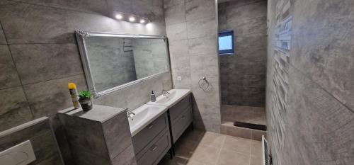 a bathroom with a sink and a mirror and a shower at Kékkút Cottage in Nagyvisnyó