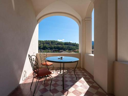 balcón con mesa, 2 sillas y ventana en Villa Agnona Camere, en Borgosesia