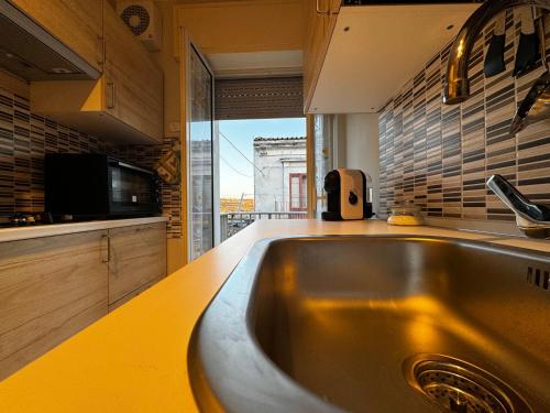 a kitchen with a stainless steel sink and a window at Casa Vacanze La Melagrana in Modica
