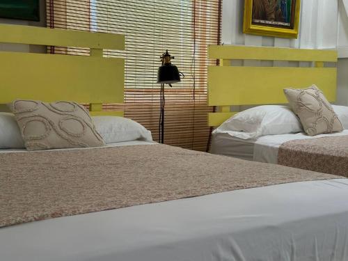 a bedroom with two beds and a lamp at Caribbean Flow in Puerto Viejo