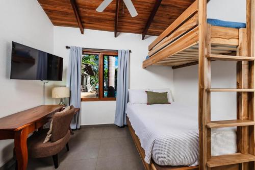 um quarto com uma cama, uma secretária e um beliche em Hacienda del Mar em Tamarindo