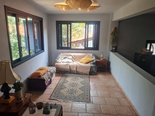 uma sala de estar com um sofá e uma mesa em Guest Mangueiras em Florianópolis