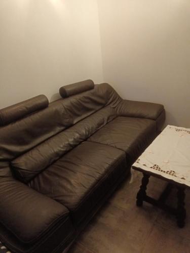 - un canapé en cuir brun dans une chambre avec une table dans l'établissement Logement T2 Indépendant meublé RDC, à Saint-Avit-Saint-Nazaire