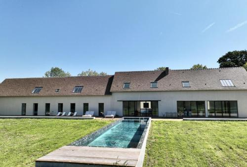ein Haus mit einem Swimmingpool davor in der Unterkunft Villa Léonard in Saint-Étienne-la-Thillaye
