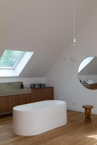 un pouf blanc dans une pièce avec un miroir dans l'établissement Villa Léonard, à Saint-Étienne-la-Thillaye
