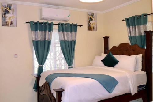 a bedroom with a bed and a window with green curtains at The Royal View (Fully AC) in Banbury