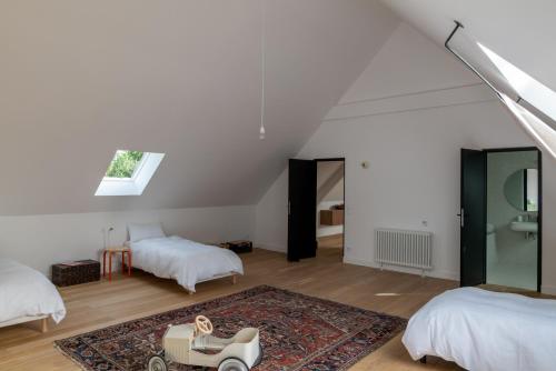ein weißes Zimmer mit 2 Betten und einem Teppich in der Unterkunft Villa Léonard in Saint-Étienne-la-Thillaye