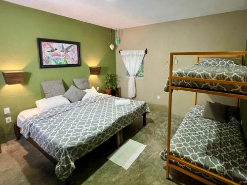 a bedroom with two beds and a bunk bed at Casa Boutique Hokhmah in Puerto Morelos