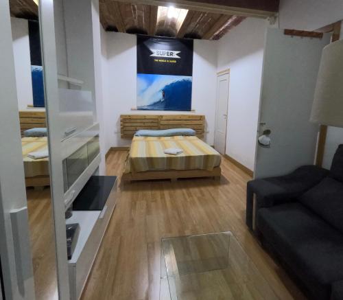 um pequeno quarto com uma cama e um sofá em MOOD City Center em Valência
