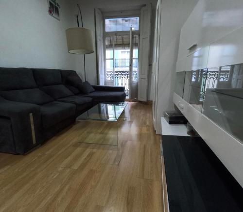 uma sala de estar com um sofá preto e um piso de madeira em MOOD City Center em Valência