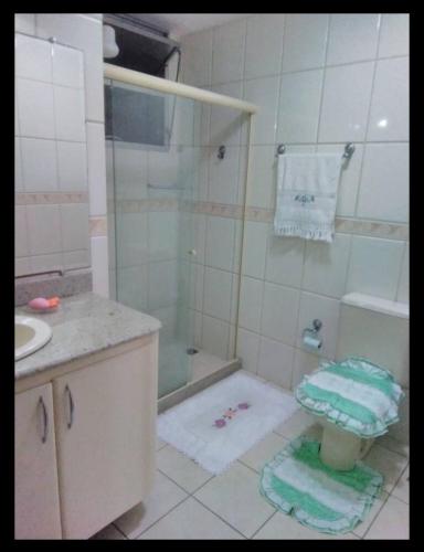 a bathroom with a shower and a toilet and a sink at Apartamento praia de Camburi in Vitória