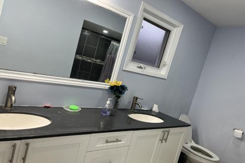 uma casa de banho com 2 lavatórios e um espelho em ShayCozyDelux-Room-101 em Pickering