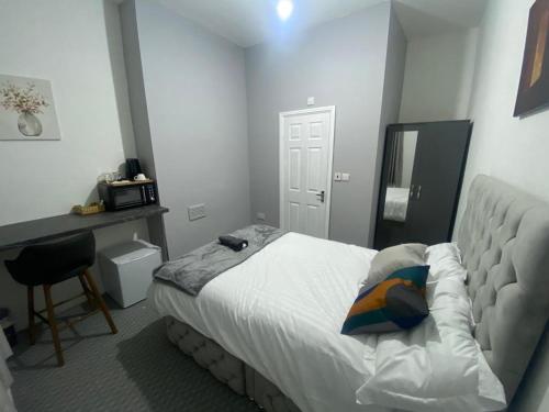 a bedroom with a bed and a desk and a mirror at Three En-Suit Rooms in Manchester
