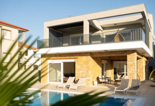 una casa con una piscina di fronte di Andreas Maisonettes and Apartments a Nikiti