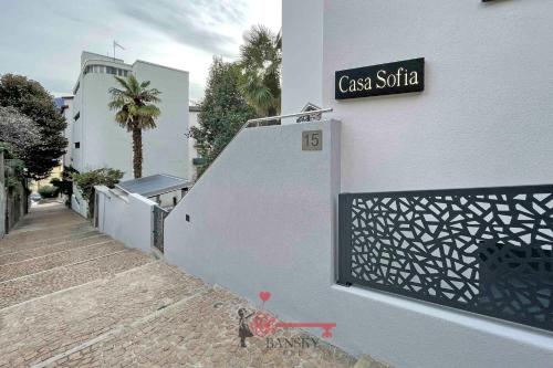 a sign on the side of a white building with a ramp at Home Sofia Room 4 - 5min Station -By EasyLife Swiss in Lugano