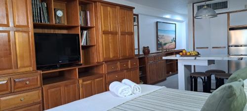 una camera da letto con un ampio centro di intrattenimento con televisore di Departamento Tipo Estudio Dynasty Isla de Margarita a Porlamar