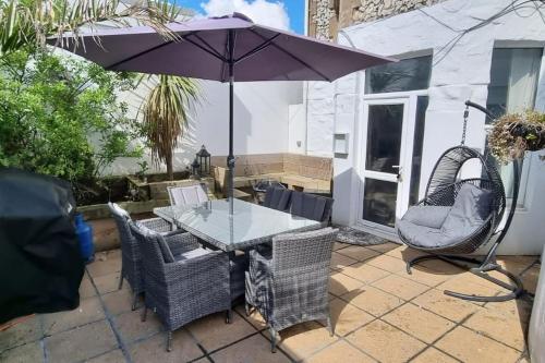 a table and chairs with an umbrella on a patio at Naughty Shades of Brighton in Brighton & Hove