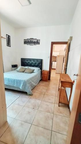 um quarto com uma cama e uma mesa de madeira em Lavalle II em Venado Tuerto