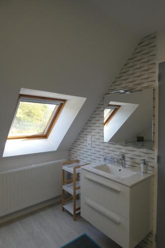 ein Badezimmer mit einem Waschbecken und einem Dachfenster in der Unterkunft Chez Valérie in Merlevenez