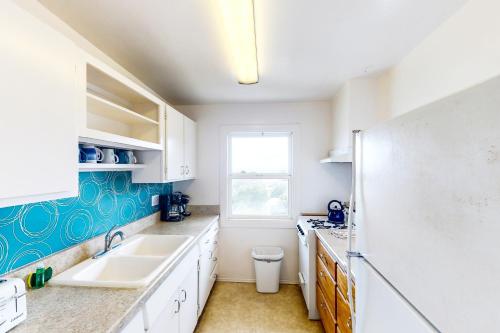 a kitchen with a sink and a refrigerator at Lillie Adventure in Summerland