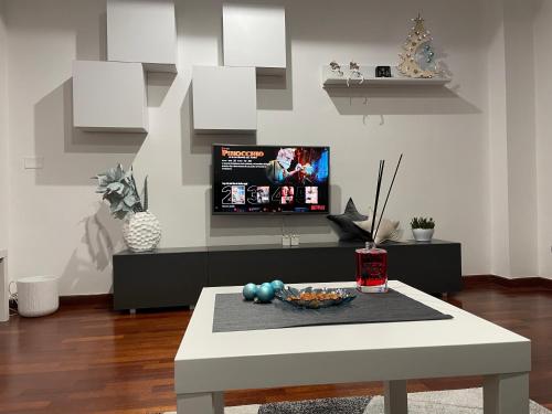 sala de estar con mesa y TV en Appartamento con WI FI e Netflix Your second House, en Volla