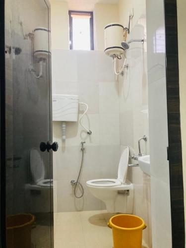 a bathroom with a toilet and a shower and a sink at Oceanic Stay And Restaurant Gokarna in Gokarn