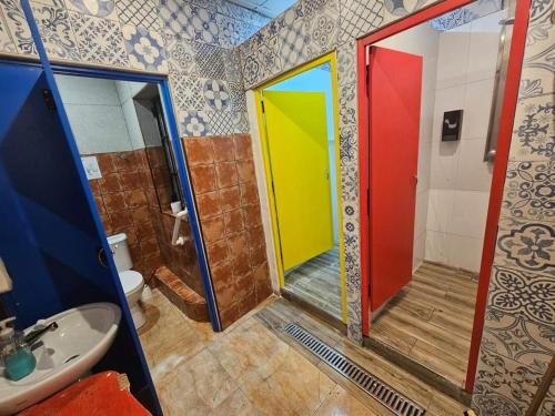 baño con puertas coloridas y lavamanos en Hostel Malti Budget, en San Julián