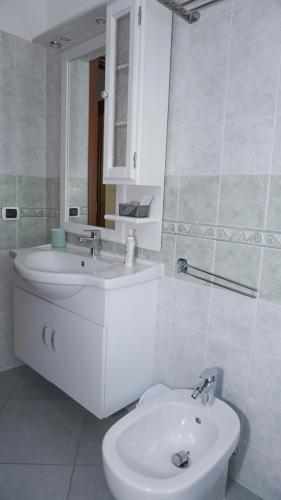 a white bathroom with a sink and a toilet at Agriturismo Le Radici in Borgo Montenero