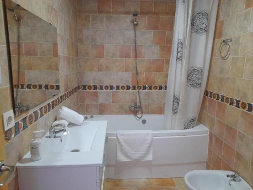 a bathroom with a tub and a toilet and a sink at Atalaya de los Bermejales Villa privada piscina in Los Morales