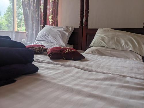 a bed with two pillows on top of it at Cwmbale Eco-Safari Lodges, Restaurant and Zoo. in Mbale