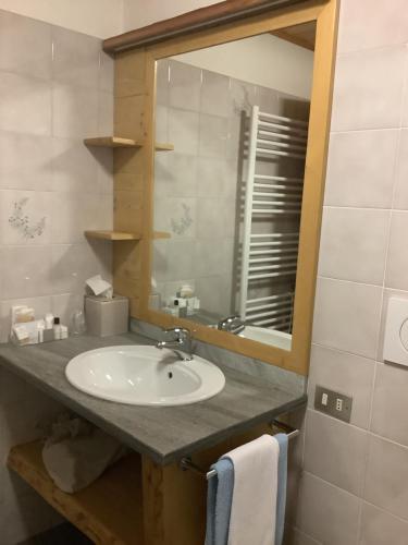La salle de bains est pourvue d'un lavabo et d'un miroir. dans l'établissement B&B Monte Giove Formazza, à Formazza