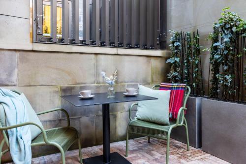 a table and two chairs with cups on a patio at Virgin Hotels Edinburgh in Edinburgh