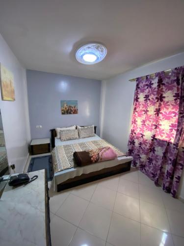 a bedroom with a bed and a purple curtain at Family house in the center of fez in Fez
