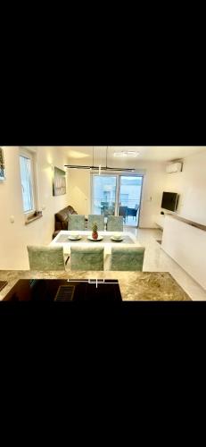 uma sala de estar com um sofá, uma mesa e cadeiras em Apartment with swimming pool Lagotto em Trogir