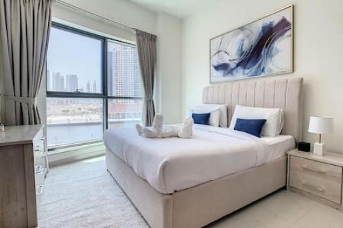 a bedroom with a large bed and a large window at Key View - The Bay in Dubai