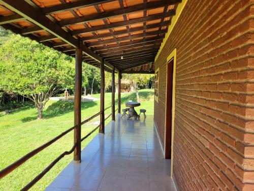 a patio with a wooden pergola on a brick building at Pousada Moinho de Pedra in Extrema