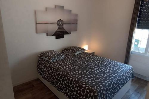 um quarto com uma cama com duas almofadas em Appartement cosy avec jardin em Floirac