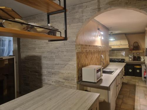 una cucina con forno a microonde bianco su un bancone di A la maison du bonheur a Neuilly-sous-Clermont