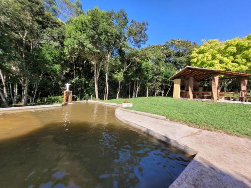 einen Teich in einem Park mit Pavillon in der Unterkunft Pousada Moinho de Pedra in Extrema
