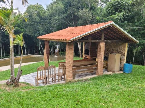a wooden gazebo with a table and chairs at Pousada Moinho de Pedra in Extrema